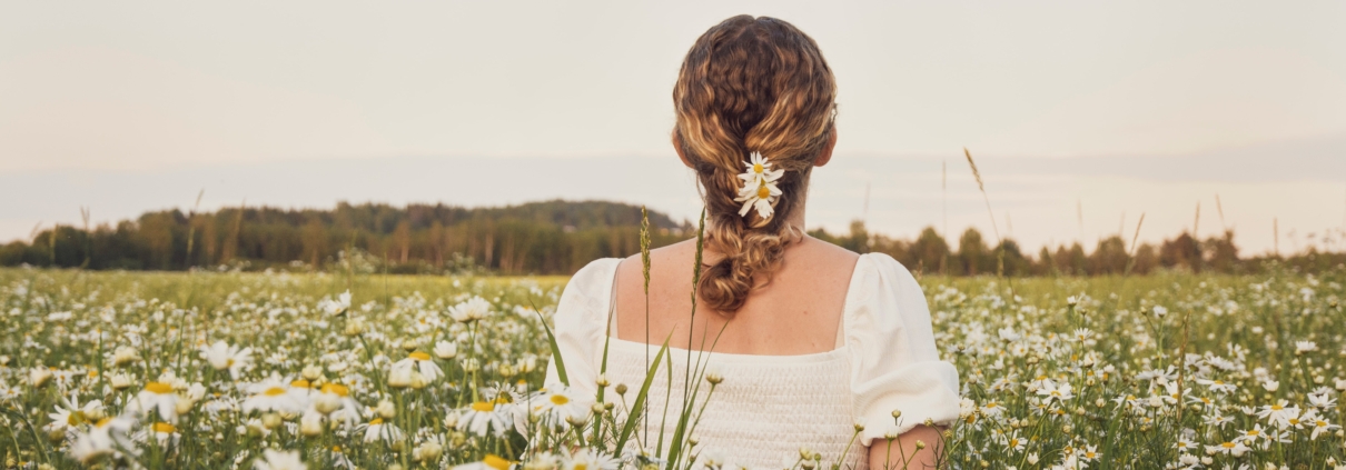 a woman in a field of flowers overcoming feelings of vulnerability