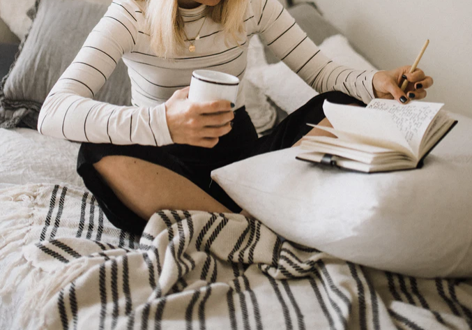 a woman in bed writing down her dreams